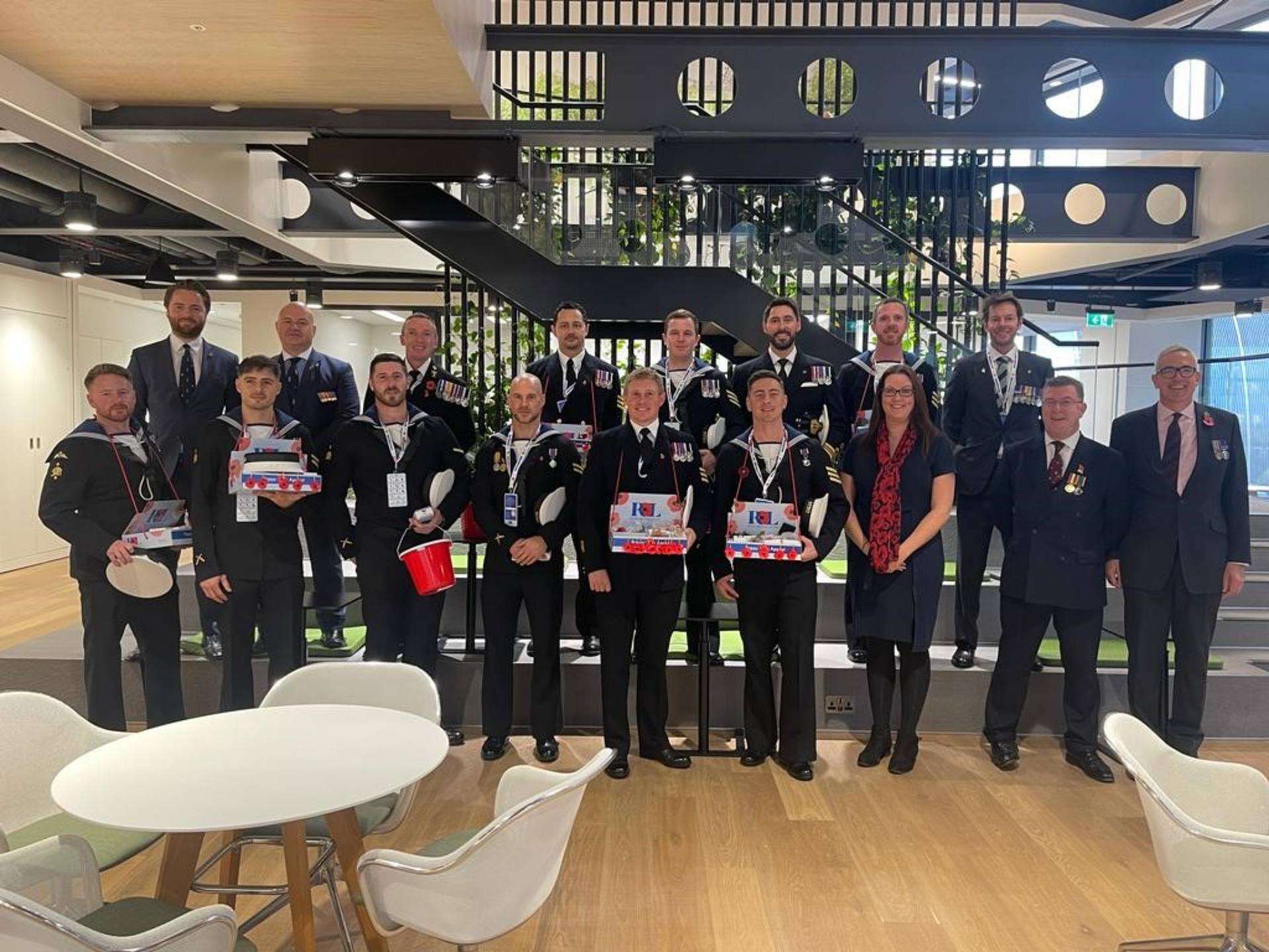 Several serving and veteran services personnel in suits and ties gathered together, showing solidarity whilst showcasing their various awards.