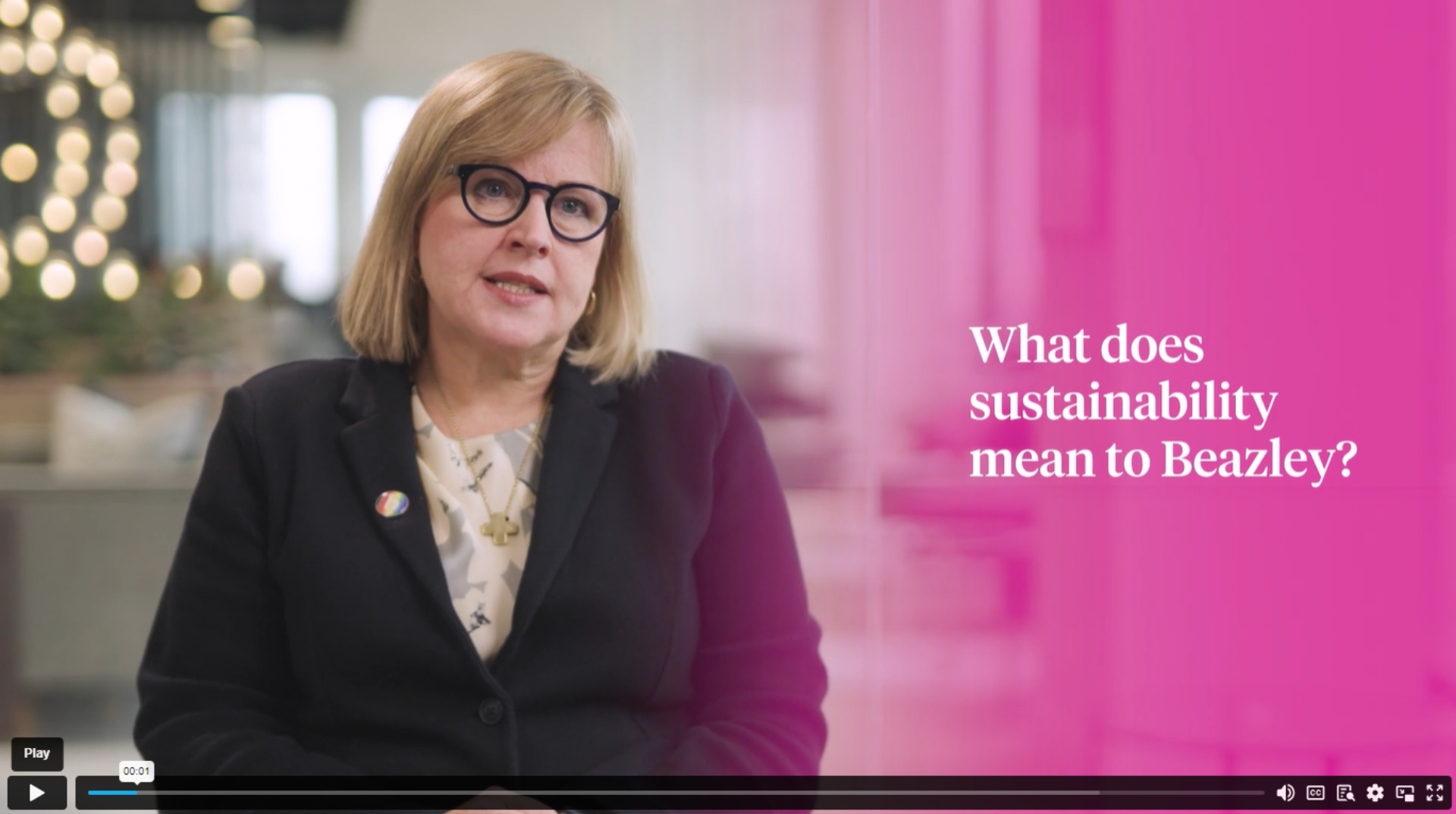 A professional woman wearing glasses and a suit jacket speaks on sustainability, highlighting the importance of eco-friendly practices.