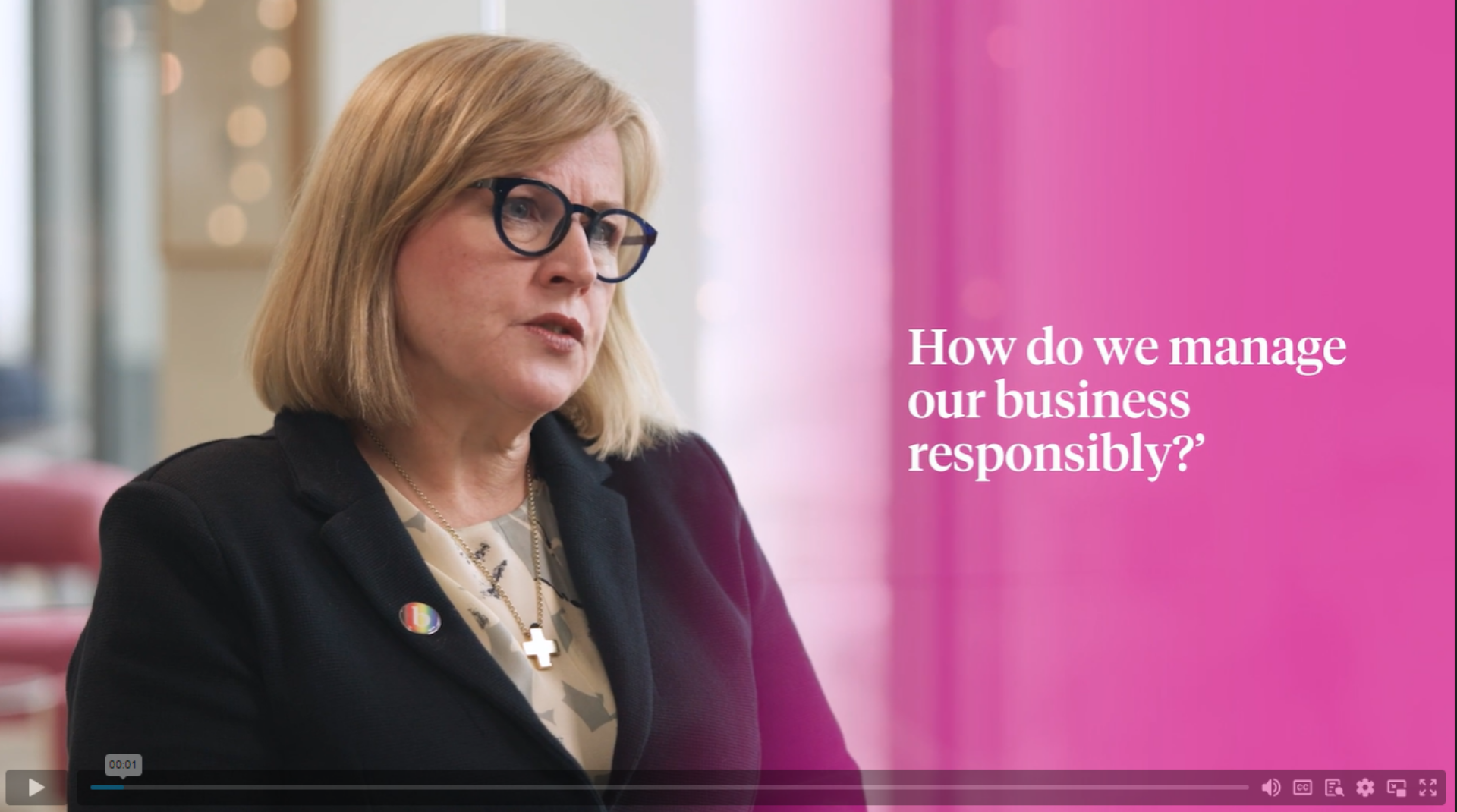 A professional woman wearing glasses and a suit jacket speaks on sustainability, highlighting the importance of eco-friendly practices.