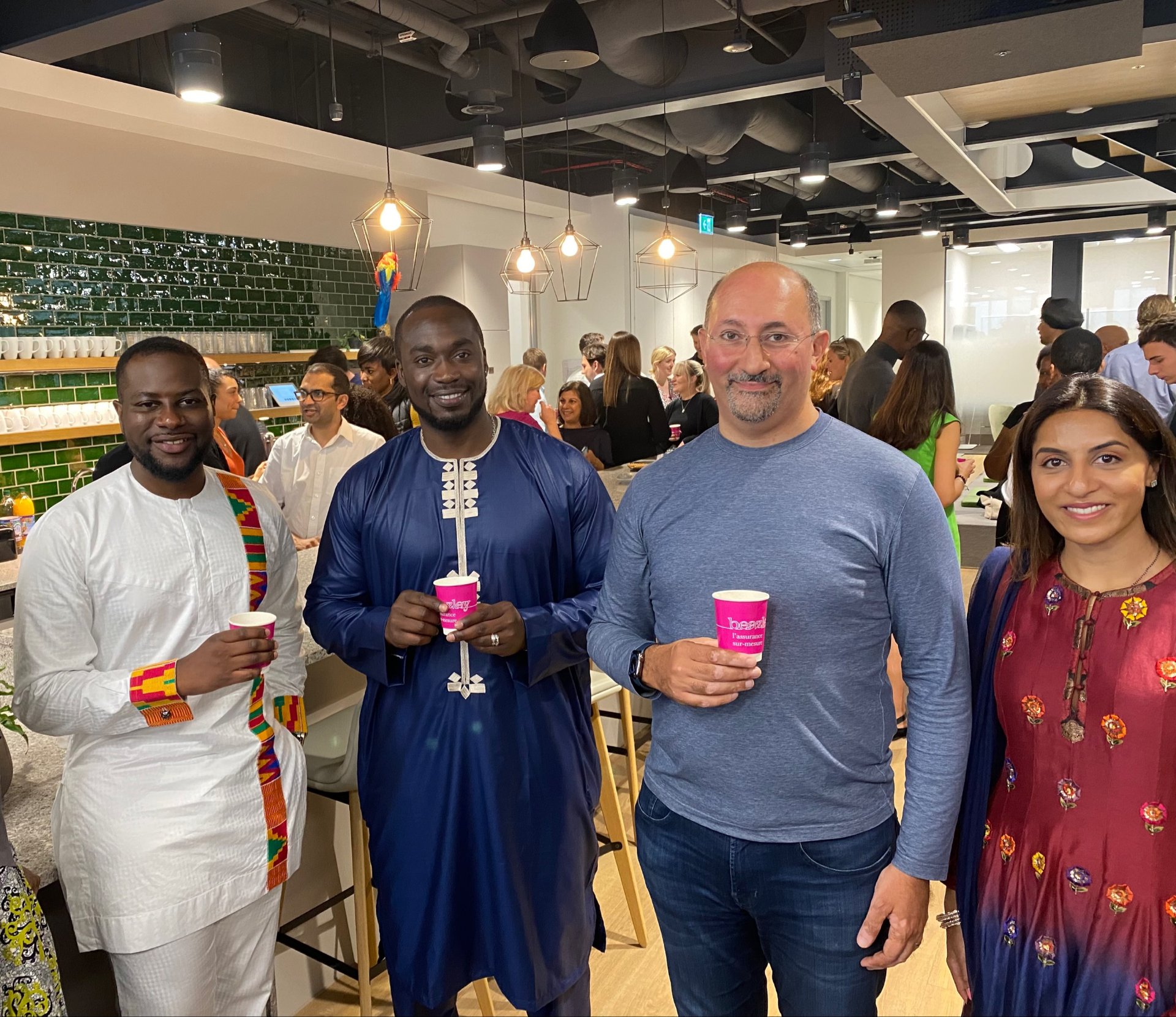 Several people gather in a room, enjoying drinks and socializing in a lively atmosphere.